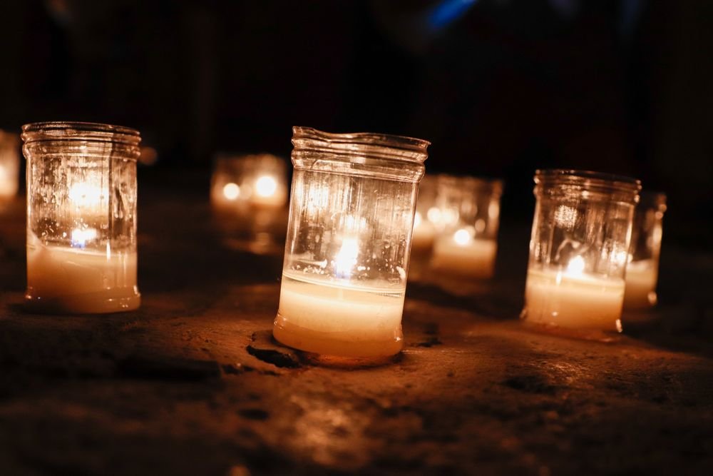 Velas acesas em potes de vidro no escuro